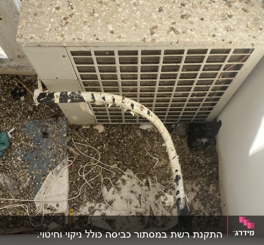 יחידת מזגן עם חוטים ופסולת על הקרקע